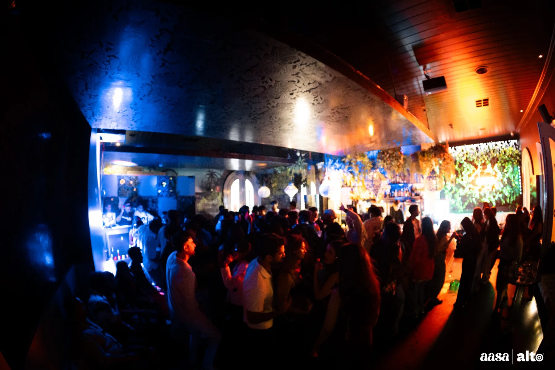 Wide view of a packed Melbourne club room during a DJ set