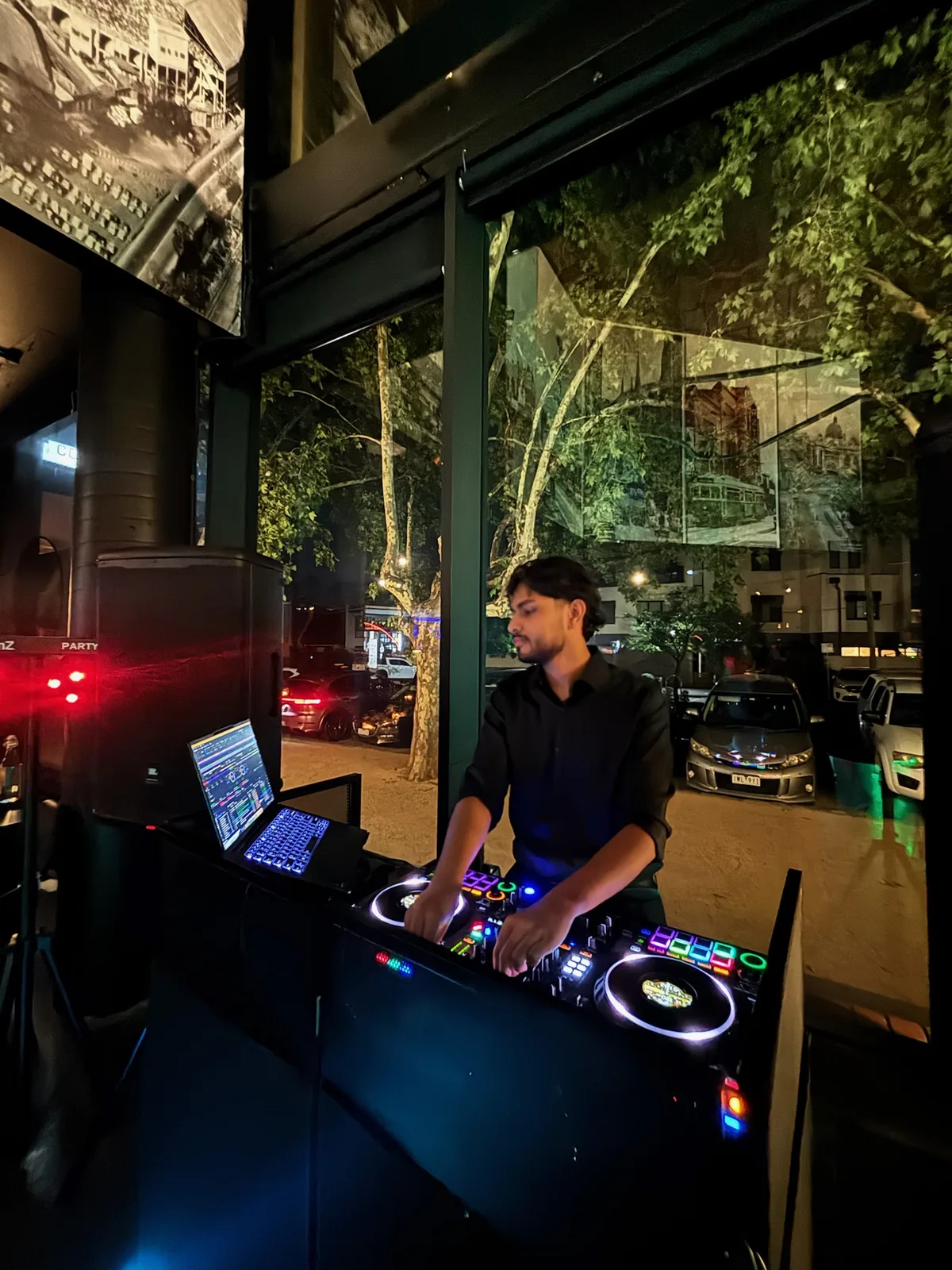 DJ Bhargav performing at night, multicoloured decks