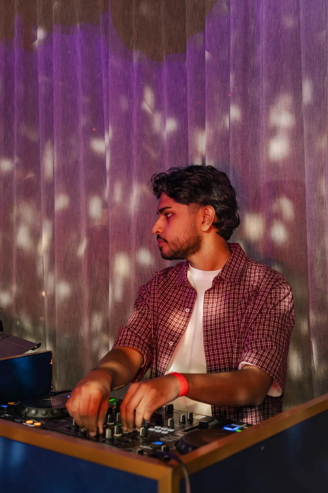 DJ Bhargav at the decks, purple curtain backdrop