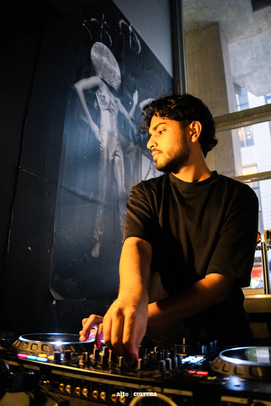 DJ Bhargav smiling behind the decks during a daytime event
